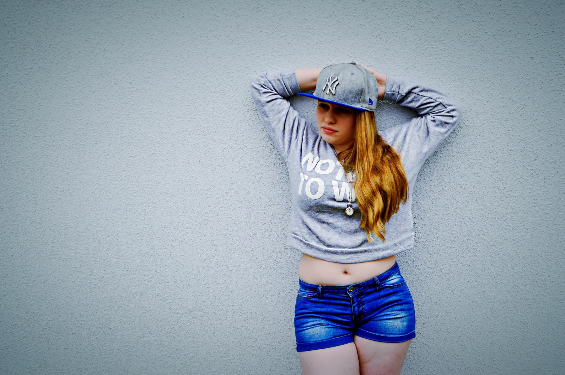 Carolin mit Cap vor einer hellen Wand