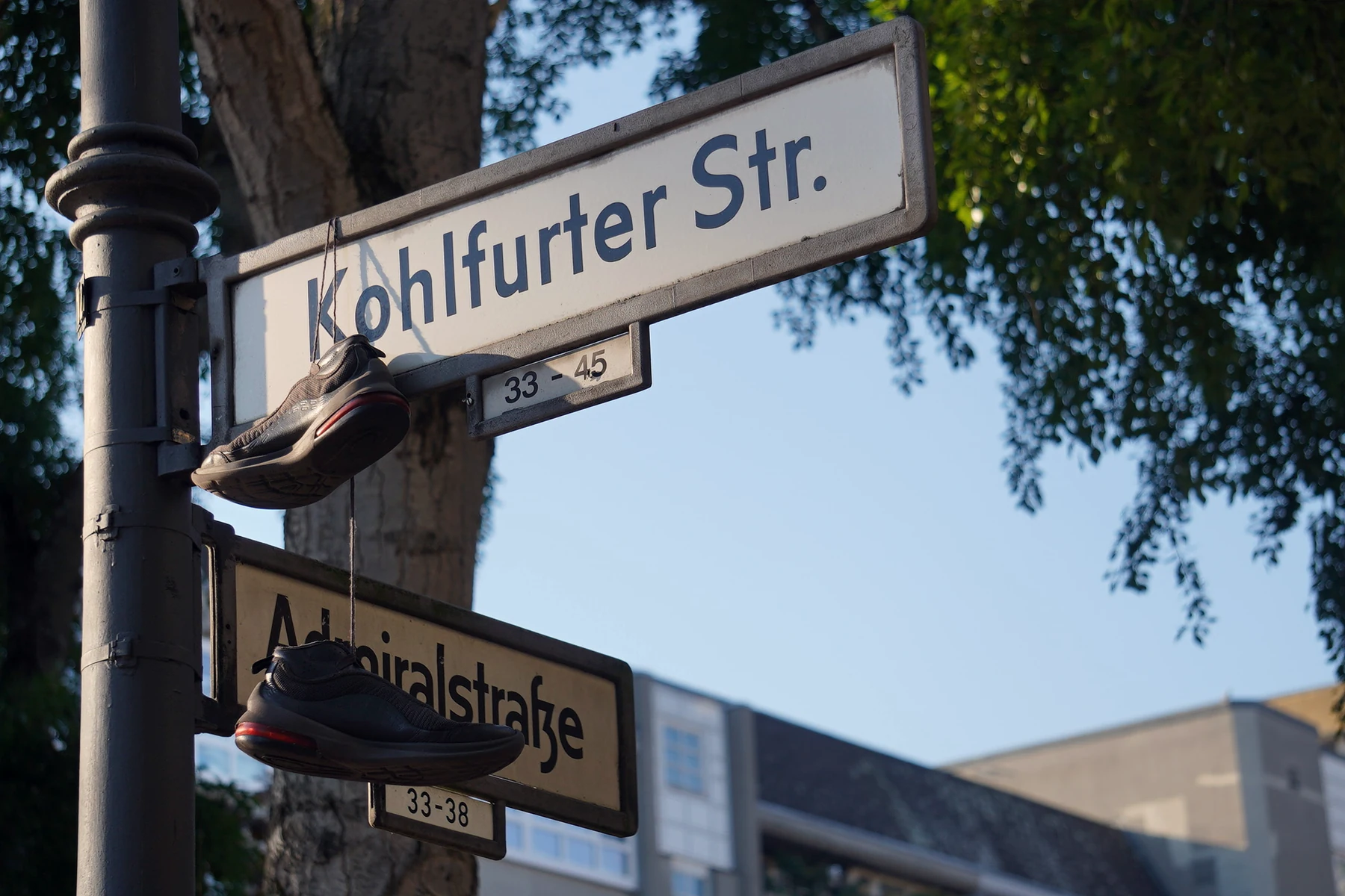 Sneaker h&auml;ngen &uuml;ber einer Stra&szlig;enecke